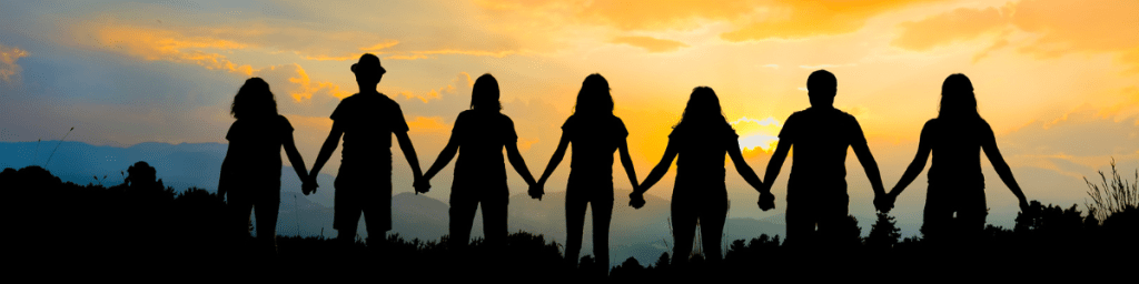 Group of people holding hands demonstrating connection.
