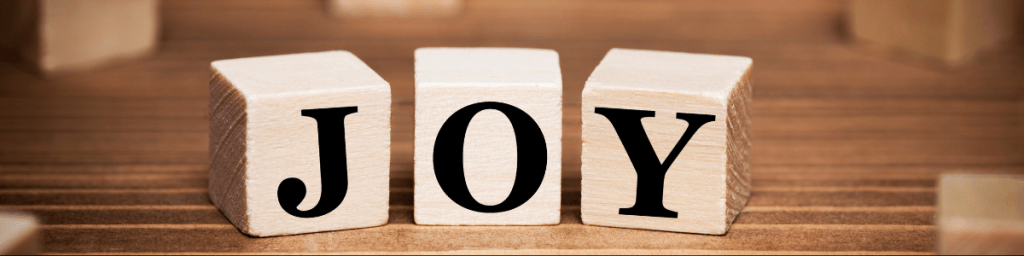 the word JOY spelled out on wooden blocks